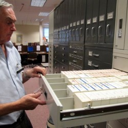Byron Ray, director of the Logan Regional Family History Center, perusing a microfilm repository. The center has over 17,000 physical volumes and even more on microfilm.